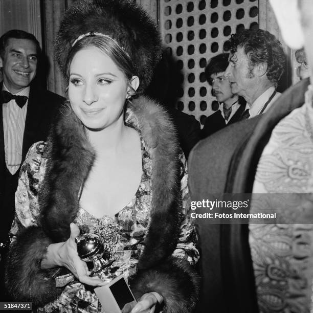 American actress and singer Barbra Streisand holds her Golden Globe award for Best Performance by an Actress in a Motion Picture - Comedy or Musical...