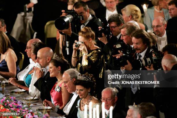 Press photographers gather behind the guests of honor, physics laureate David H. Politzer, Crown Princess Victoria, physics laureate David J. Gross...