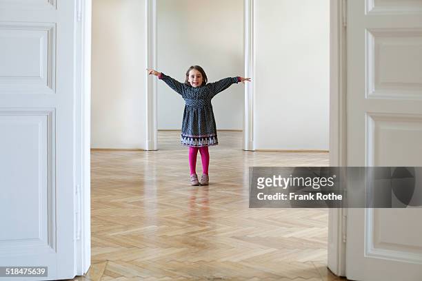 young girl in a big empty flat with wooden floor - child arms raised stock pictures, royalty-free photos & images