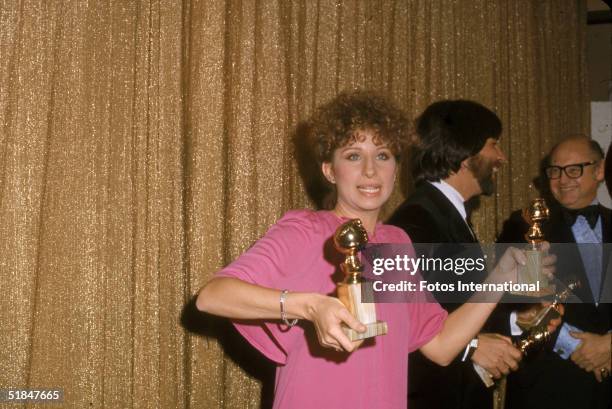 American actress and singer Barbra Streisand holds her two awards at the 34th Annual Golden Globe Awards, held at the Beverly Hilton Hotel, Beverly...