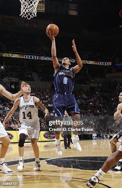 Howard Eisley of the Utah Jazz shoots past Beno Udrih of the San Antonio Spurs during the game at SBC Center on November 27, 2004 in San Antonio,...