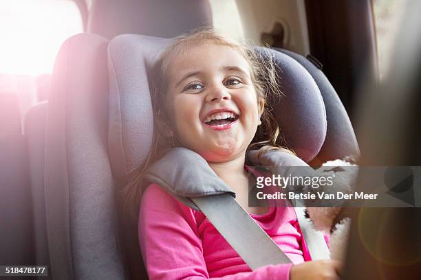 portrait of girl laughing, sitting in car seat. - child car seat foto e immagini stock
