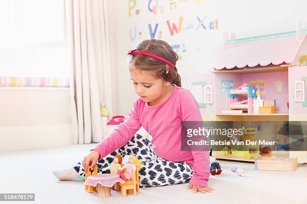 young girl playing with dolls house in bedroom. - bambola giocattolo foto e immagini stock