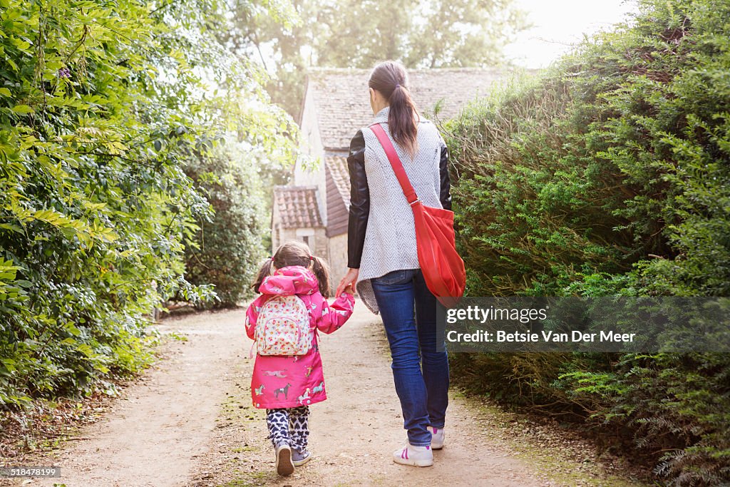 Mother and daughter walking to school.