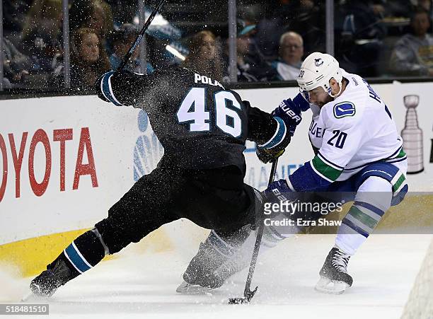 Chris Higgins of the Vancouver Canucks and Roman Polak of the San Jose Sharks go for the puck at SAP Center on March 31, 2016 in San Jose, California.