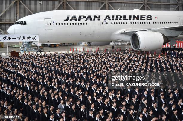 New employees of Japan Airlines Group attend an entrance ceremony at a hangar in Tokyo's Haneda Airport on April 1, 2016. 1,460 new employees of JAL...