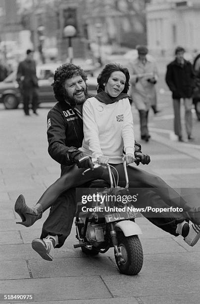 English radio broadcaster and DJ Dave Lee Travis pictured riding a mini bike with actress Judy Carne in Lower Regent Street, London on 6th January...