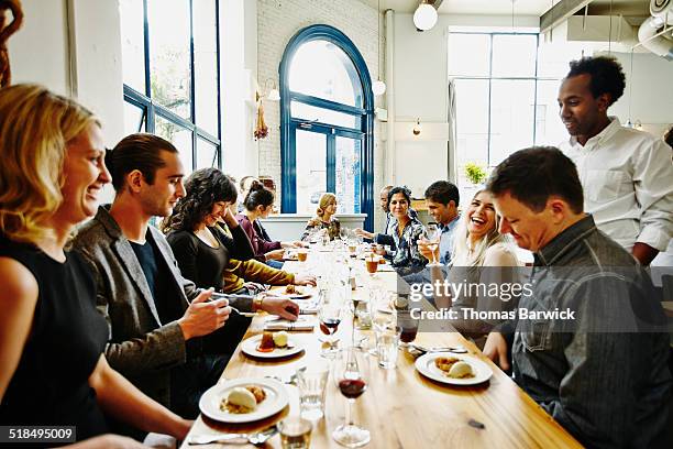 laughing friends in restaurant eating dessert - ereignis atmosphäre stock-fotos und bilder