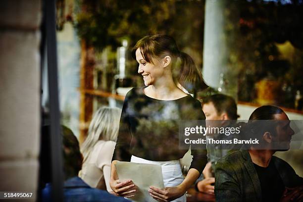 smiling waitress taking order view through window - waitress foto e immagini stock