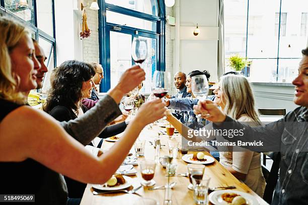 group of friends toasting at dinner party - victory dinner stockfoto's en -beelden