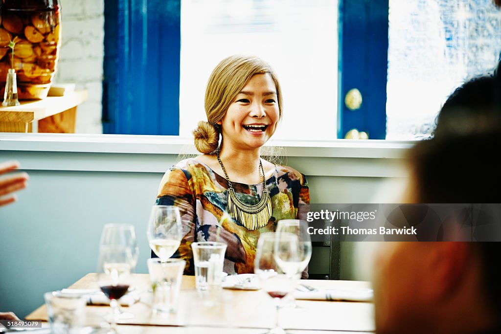 Woman sitting at table with friends in restaurant