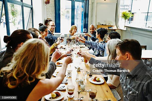 smiling group of friends toasting at dinner party - 豪華　食事 ストックフォトと画像