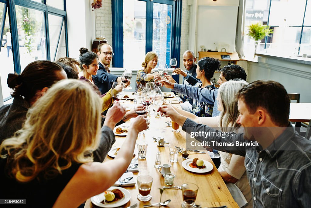 Smiling group of friends toasting at dinner party