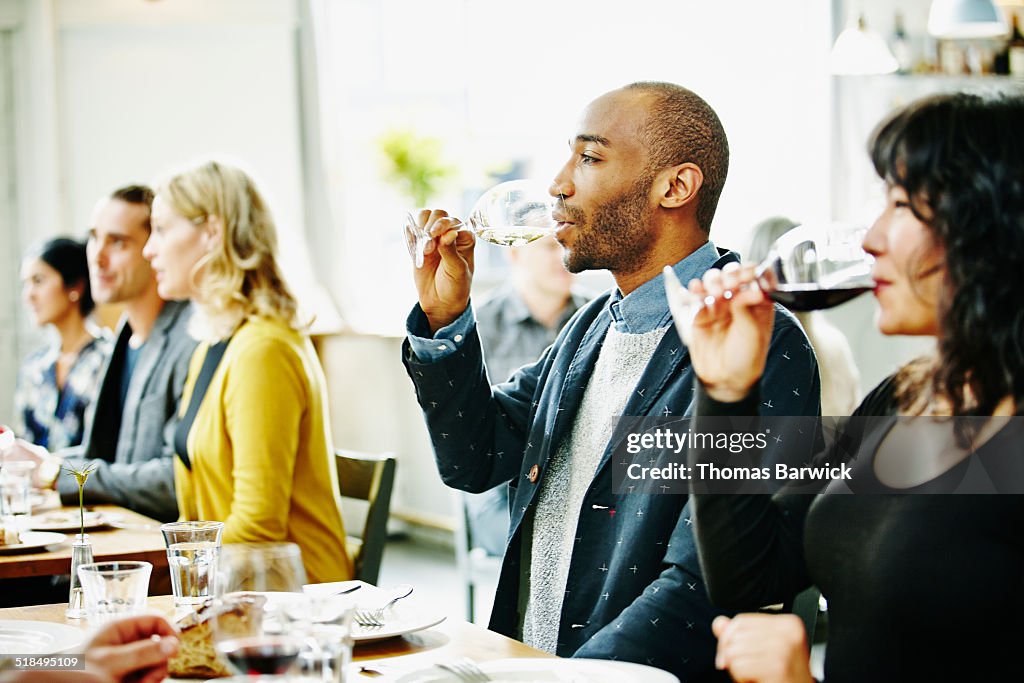 Friends at table in restaurant drinking wine