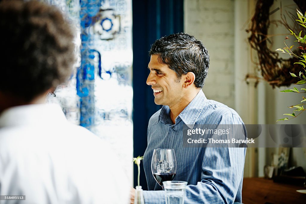 Smiling mature man in discussion at restaurant bar