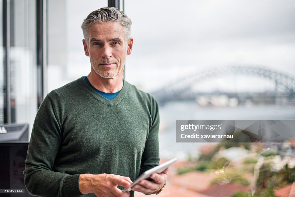 Retrato de un hombre de negocios con tableta digital en oficina