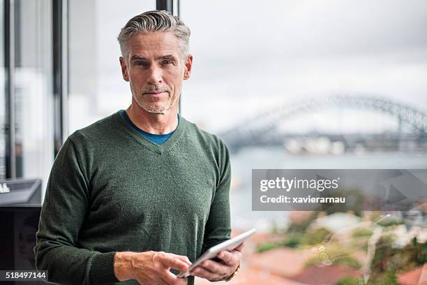 retrato de um homem de negócios com tablet digital no escritório - looking at camera australia imagens e fotografias de stock