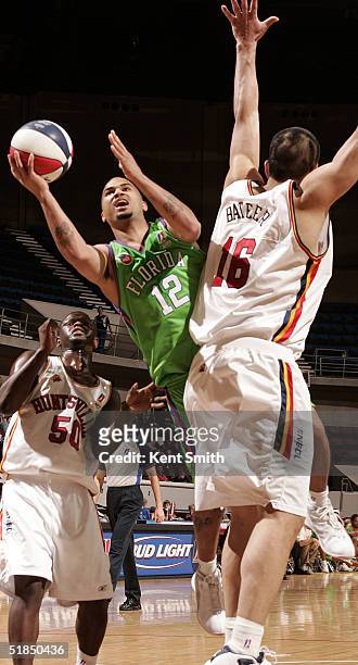 Kevin Braswell of the Florida Flame slips by for the shot against Mengke Bateer of the Huntsville Flight on December 11, 2004 at the Von Braun Center...