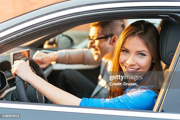 porträt von attraktive junge paar fahren in luxus-auto in der stadt - luxury car stock-fotos und bilder
