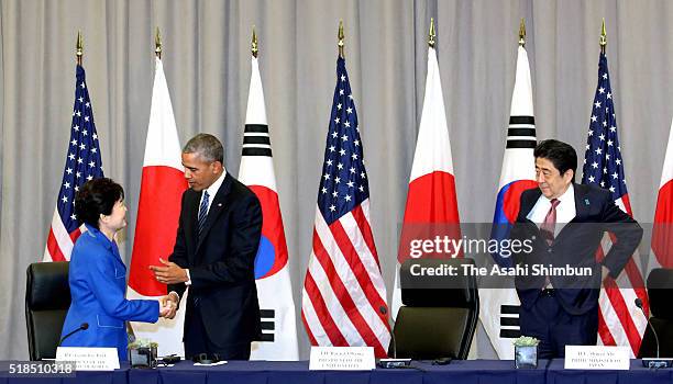 South Korean President Park Geun-Hye greets U.S. President Barack Obama while Japanese Prime Minister Shinzo Abe looks on during a meeting at the...