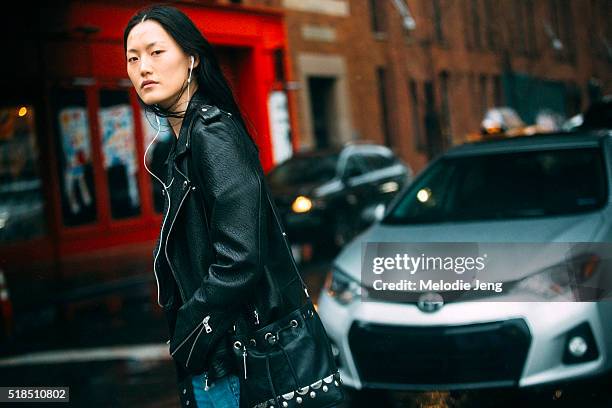 Korean model Hye Seung Lee wears earphones, a black leather jacket and carries a black leather bucket bag with metal emballishments after the Ohne...