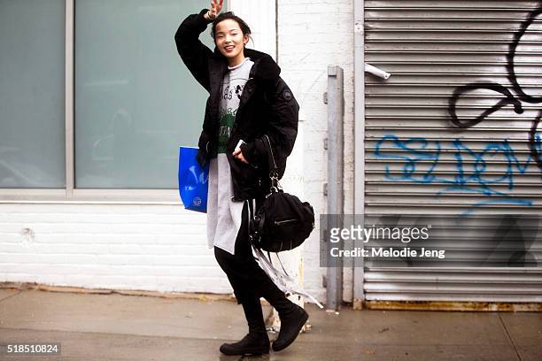 Chinese supermodel Xiao Wen Ju wears a black Canada Goose coat and a gray cotton dress with a fringe after the Rodarte show during New York Fashion...