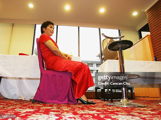 Wu Huawen, a 44 year-old contestant takes a break after a news conference promoting the first Miss Plastic Surgery on December 12, 2004 in Beijing,...