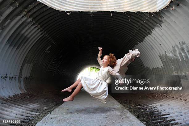 red haired girl floating in tunnel - red dress child stock pictures, royalty-free photos & images