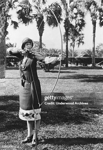 Elizabeth Detwiller gives a demonstration of her skills with the longbow at the Hotel Ormond, Ormond Beach, Florida, February 9, 1926. She is the...