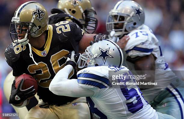 Running back Deuce McAllister of the New Orleans Saints runs against Scott Shanle of the Dallas Cowboys on December 12, 2004 at Texas Stadium in...