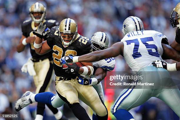 Running back Deuce McAllister of the New Orleans Saints runs past Marcellus Wiley of the Dallas Cowboys on December 12, 2004 at Texas Stadium in...