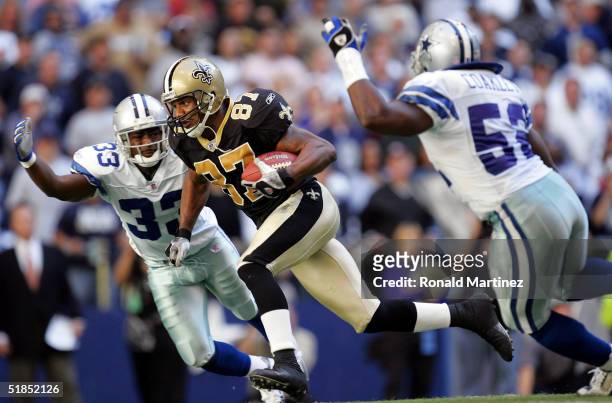 Wide receiver Joe Horn of the New Orleans Saints runs between Nathan Jones and Dexter Coakley of the Dallas Cowboys on December 12, 2004 at Texas...