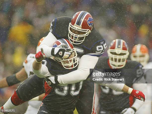 Sam Adams of the Buffalo Bills jumps on the back of teammate Chris Kelsay after Kelsay sacked Luke McCown of the Cleveland Browns December 12, 2004...