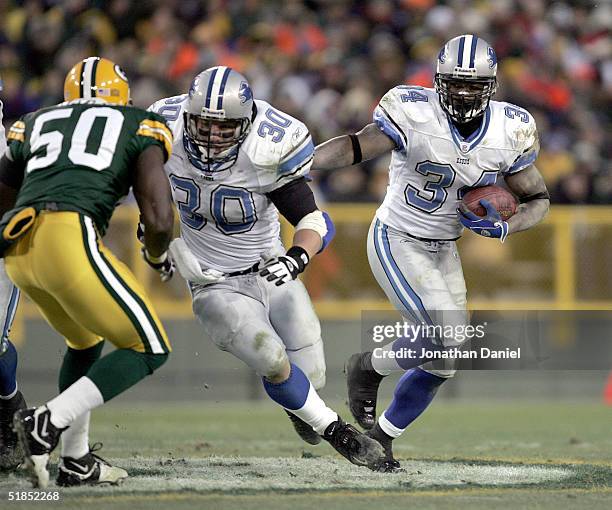 Running back Kevin Jones of the Detroit Lions finds running room behind the block of fullback Cory Schlesinger against linebacker Hannible Navies of...