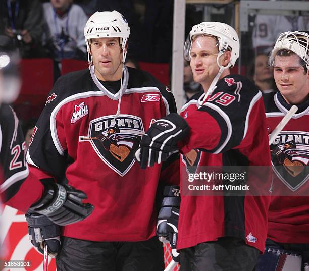 Todd Bertuzzi, Markus Naslund and Dan Cloutier of the Vancouver Canucks stand on the ice during the Brad May and Friends Hockey Challenge at the...