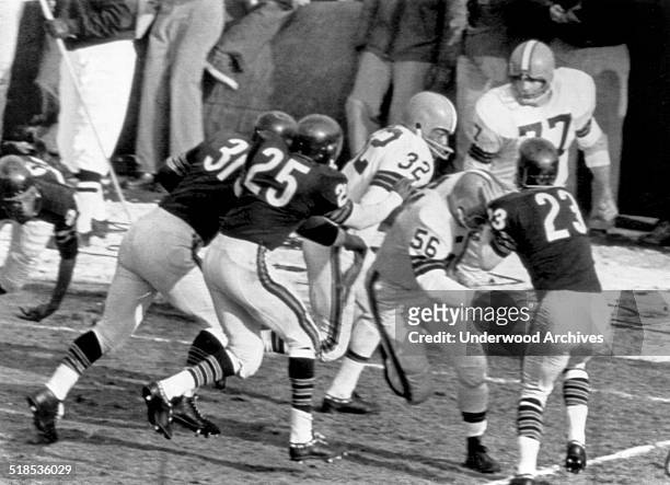 The Cleveland Browns' John Morrow makes a block on the Chicago Bears' Dave Whitsell and the Brown's running star Jim Brown is off for a 90 yard run...