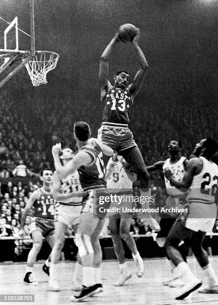 Wilt Chamberlain, Philadelphia , goes up high to snag a rebound in the NBA All-Star game, St Louis, Missouri, January 16, 1962. Below him are Bob...