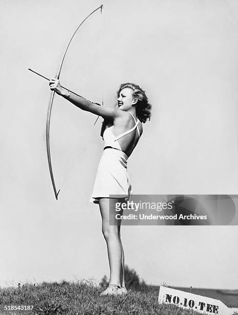 Actress Virginia Grey takes aim with a bow and arrow in the new Hollywood sport fad, archery golf, Hollywood, California, September 26, 1936.