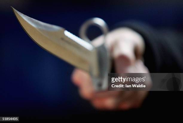 Hunting knife is held by an employee at a film and television prop company December 13, 2004 in London, England. Families of stabbing victims have...