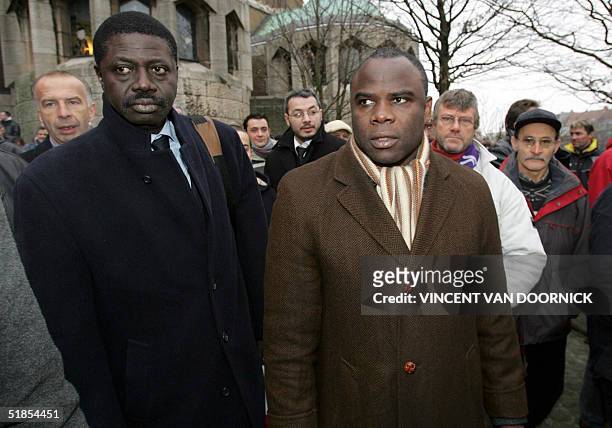 Olympic Marseille General Manager Pape Diouf and former player Basile Boli leave the Basilique of Koekelberg, in Brussels, after the funeral service...