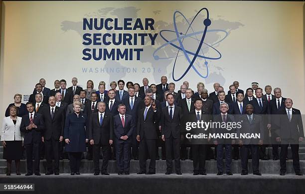 President Barack Obama gestures as he tells photographers that he and other world leaders are waiting for two more delegates to join them for a...