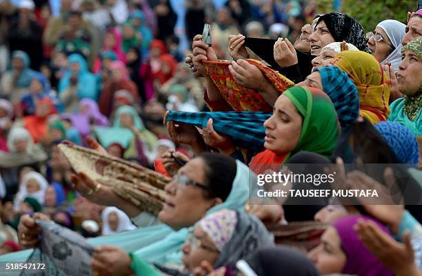 Kashmiri Muslims react as a cleric shows a relic believed to be a hair from the beard of the Prophet Mohammed during special prayers on the death...
