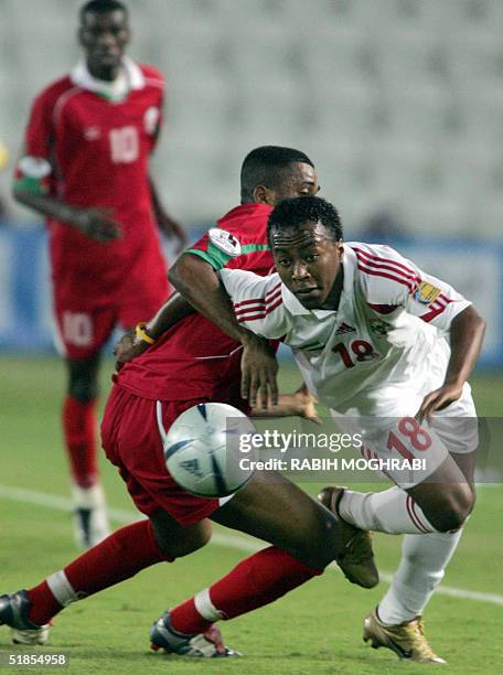 Emirati Ismail Matar eyes the ball as he duels Mohammed al-Noubi of Oman, during their 17th Arabian Gulf Cup football tournament in Doha 13 December...