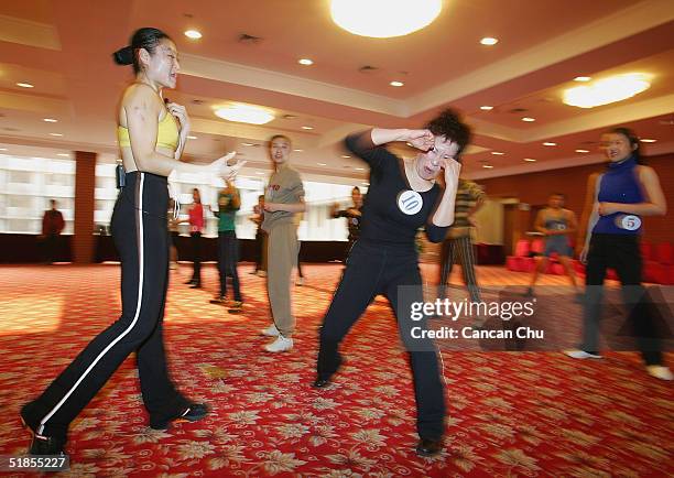 Wu Huawen , a 44 year-old contestant, takes part in a training session during China's first ever Miss Plastic Surgery contest on December 13, 2004 in...