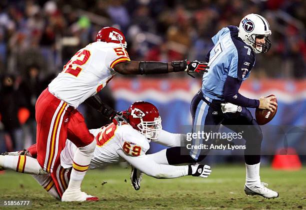 Quarterback Billy Volek of the Tennessee Titans tries to avoid Quinton Carver and Jared Allen of the Kansas City Chiefs during Monday Night Football...