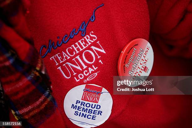 Chicago teacher picketing during a one-day strike wears a Chicago Teachers Union Local 1 sweater and a sticker and button on April 1, 2016 in...