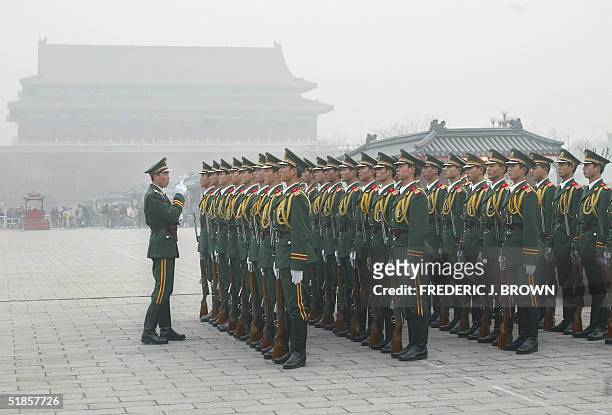 Chinese paramilitary officers are lectured during afternoon drills at the Forbidden City as a haze of smog hovers over Beijing, 14 December 2004....