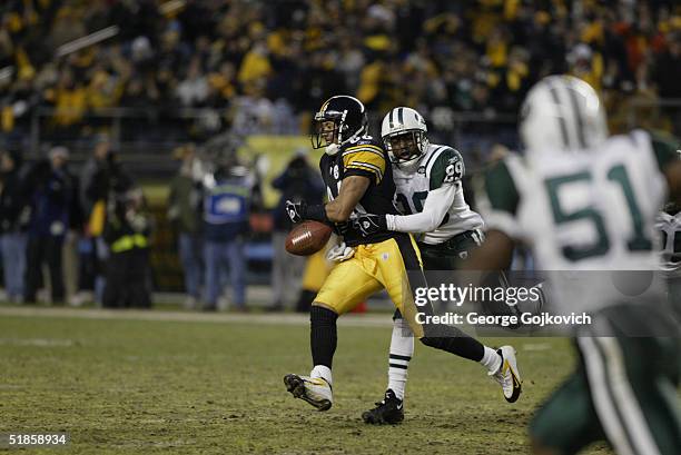 Wide receiver Hines Ward of the Pittsburgh Steelers fumbles the ball as he is hit by cornerback Donnie Abraham of the New York Jets at Heinz Field on...