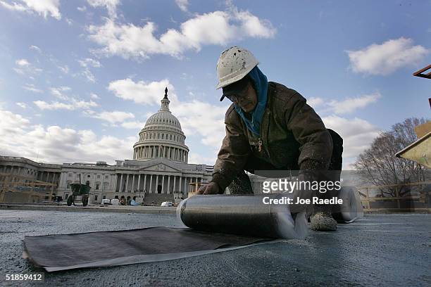 Construction worker works in front of the United States Capitol during construction of The Capitol Visitor Center December 14, 2004 in Washington,...