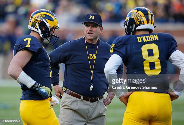Head coach Jim Harbaugh of the Michigan Wolverines talks with Shane Morris and John O'Korn during the Michigan spring game on April 1, 2016 at...